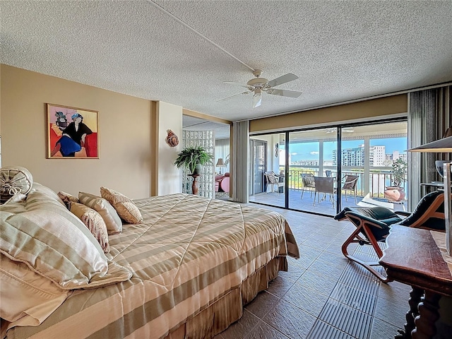 bedroom with access to exterior, ceiling fan, and a textured ceiling