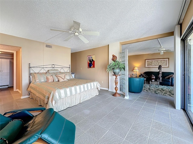 bedroom featuring visible vents, ceiling fan, and a textured ceiling