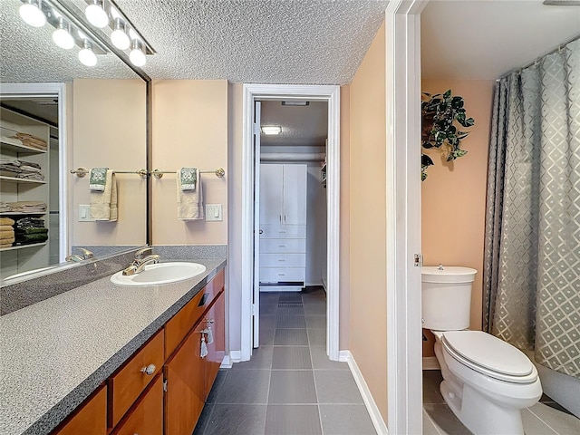 bathroom with baseboards, toilet, tile patterned flooring, a textured ceiling, and vanity