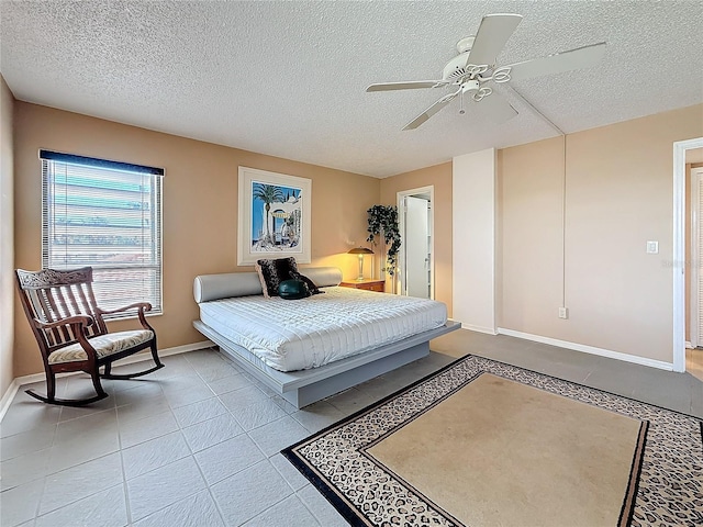 tiled bedroom with baseboards, a ceiling fan, and a textured ceiling