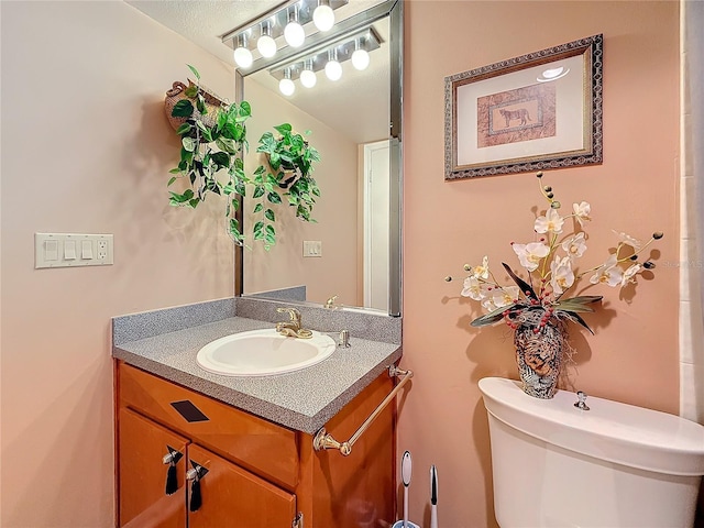 half bathroom with vanity and toilet