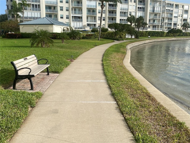 view of community with a water view and a lawn