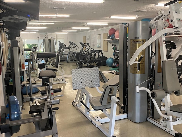 exercise room with visible vents and a textured ceiling