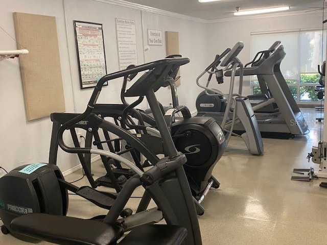 exercise room featuring baseboards and crown molding