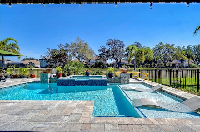 view of swimming pool featuring a patio area, a pool with connected hot tub, and a fenced backyard