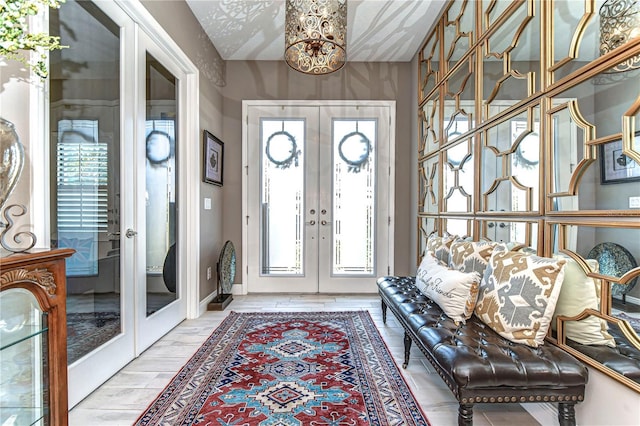 entryway with french doors, wood finish floors, and baseboards