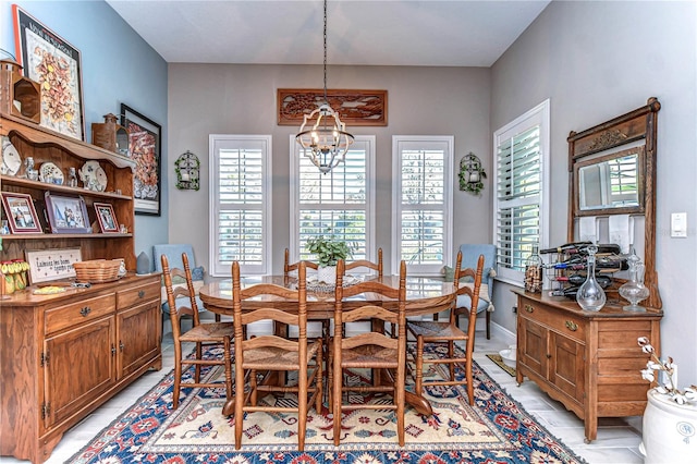 dining room featuring a healthy amount of sunlight, baseboards, and an inviting chandelier