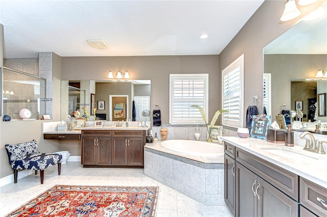 full bathroom featuring a garden tub, a stall shower, two vanities, and a sink