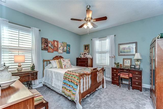 carpeted bedroom with ceiling fan and baseboards