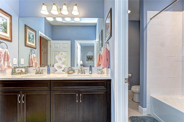 bathroom featuring tile patterned floors, a sink, toilet, and double vanity