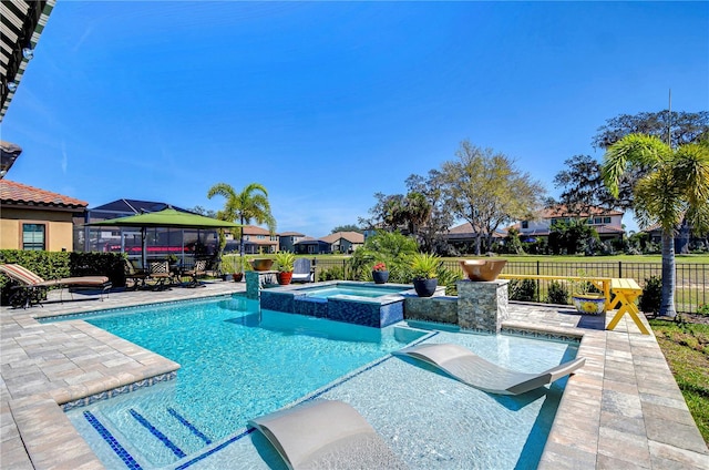 view of swimming pool featuring a patio, a fenced backyard, and a pool with connected hot tub