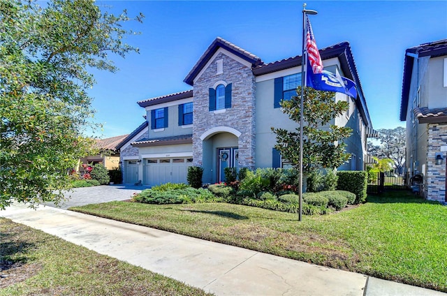 mediterranean / spanish-style home featuring a garage, stone siding, driveway, stucco siding, and a front lawn