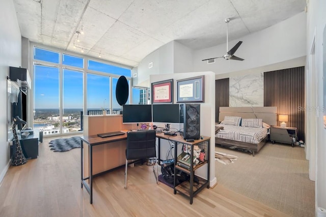 bedroom with expansive windows, wood finished floors, and visible vents