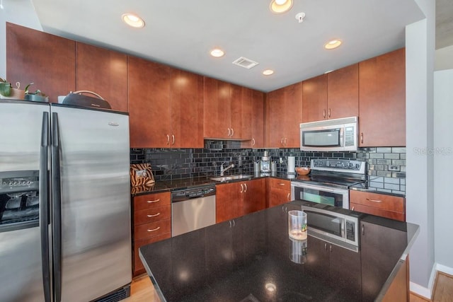 kitchen with stainless steel appliances, recessed lighting, tasteful backsplash, visible vents, and a sink