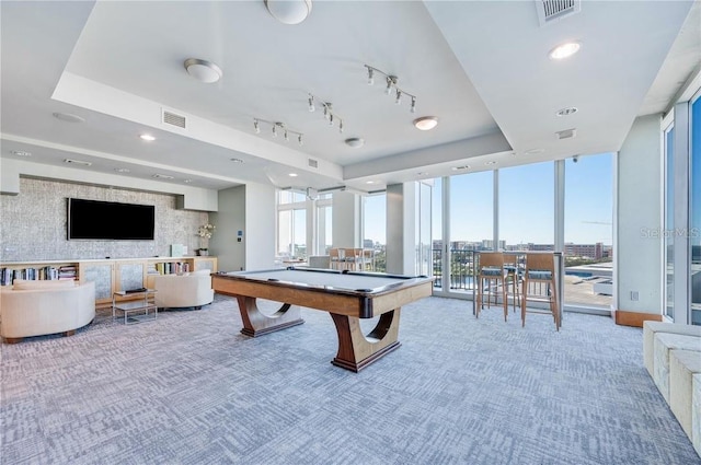 rec room featuring expansive windows, a raised ceiling, visible vents, and carpet flooring