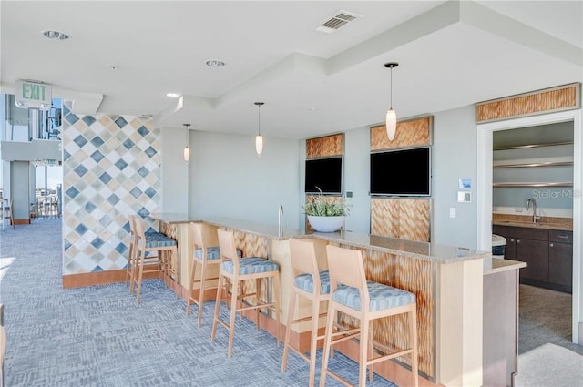 bar featuring visible vents, decorative light fixtures, wet bar, carpet floors, and a sink