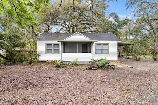 view of front of house featuring dirt driveway and a carport