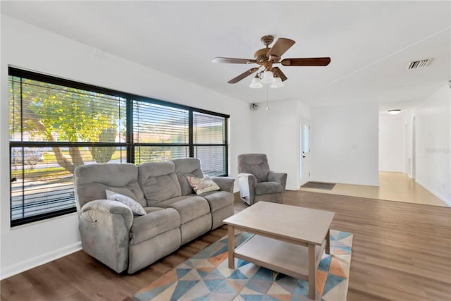 living area featuring ceiling fan, visible vents, and wood finished floors