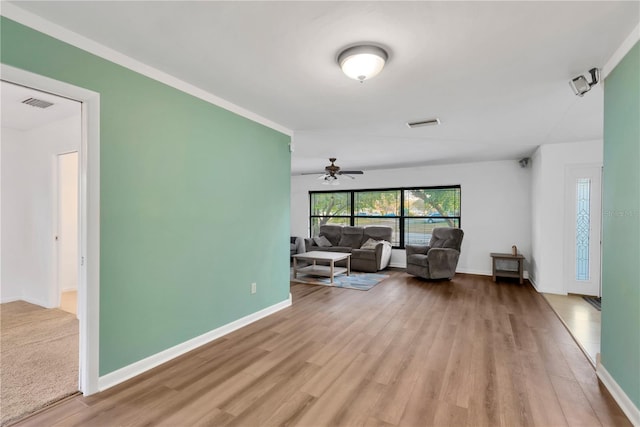 living area featuring baseboards, visible vents, and wood finished floors