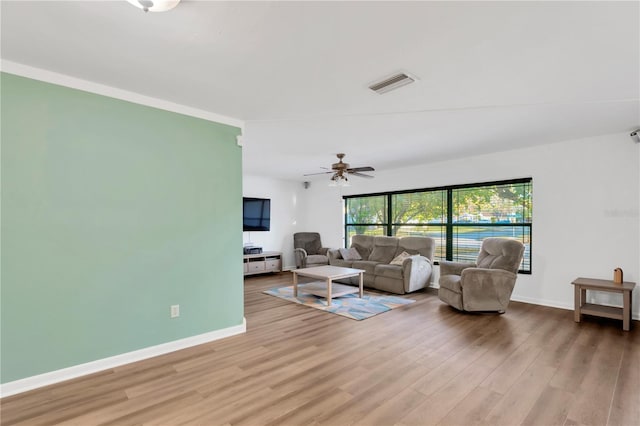 living room with visible vents, baseboards, and wood finished floors