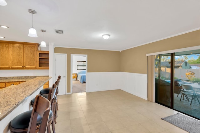 kitchen with a wainscoted wall, open shelves, ornamental molding, and pendant lighting