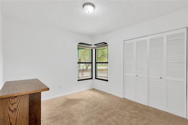 unfurnished bedroom featuring a closet, carpet, and baseboards