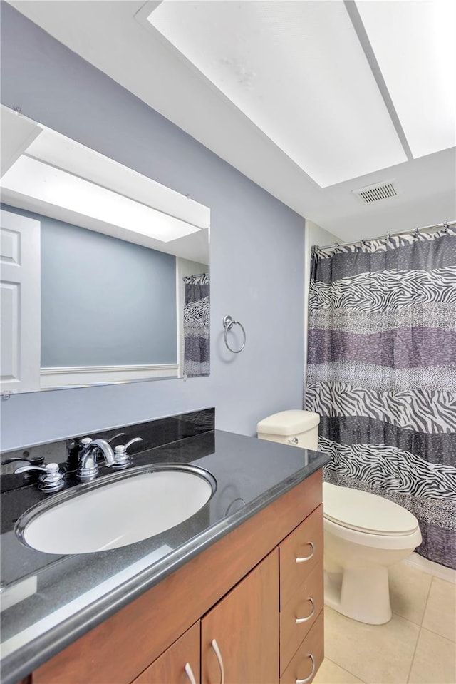 bathroom with visible vents, vanity, toilet, and tile patterned floors