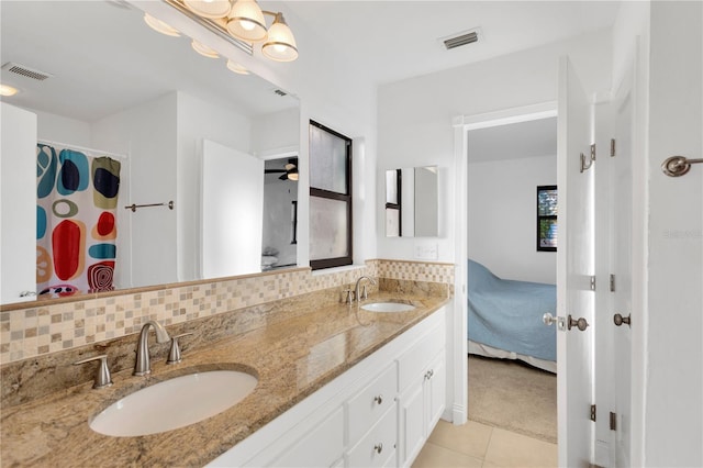 ensuite bathroom featuring backsplash, a sink, visible vents, and connected bathroom