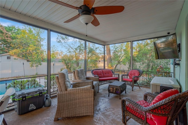 sunroom featuring a ceiling fan and plenty of natural light