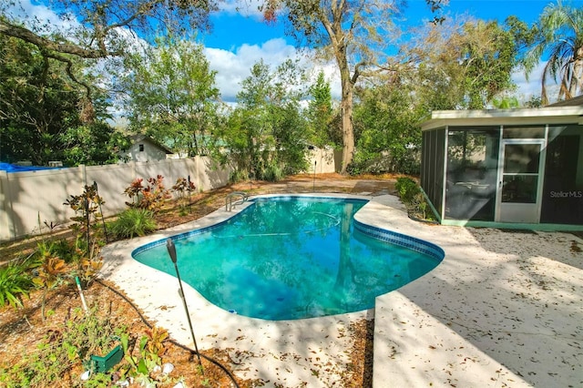 view of swimming pool featuring a fenced backyard, a sunroom, and a fenced in pool