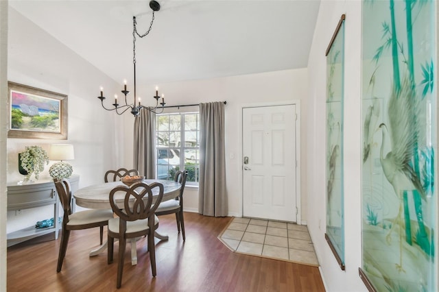 dining space featuring lofted ceiling, a chandelier, and wood finished floors