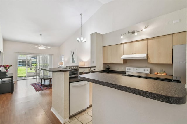 kitchen with dishwasher, dark countertops, a peninsula, under cabinet range hood, and light brown cabinets