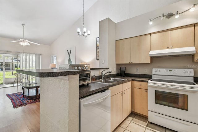 kitchen with light brown cabinets, under cabinet range hood, a peninsula, white appliances, and a sink