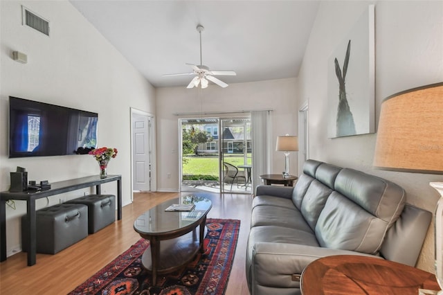 living room with a ceiling fan, visible vents, baseboards, and wood finished floors