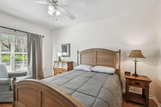 bedroom with a ceiling fan, baseboards, and wood finished floors