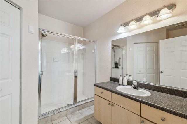 bathroom with vanity, tile patterned flooring, a shower stall, and visible vents