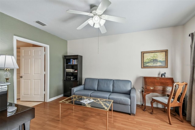 living room featuring baseboards, wood finished floors, visible vents, and a ceiling fan