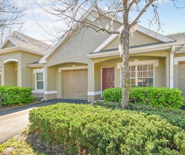 view of front of home featuring a garage, driveway, and stucco siding