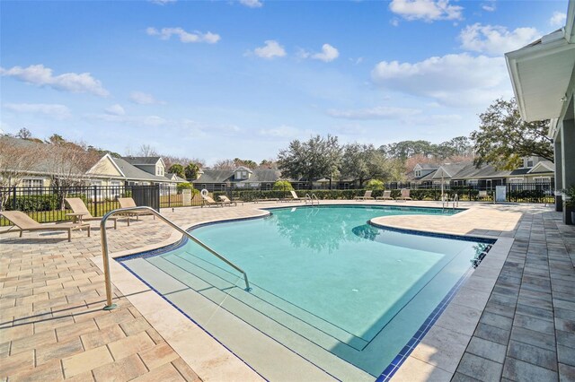 pool featuring a residential view, a patio area, and fence