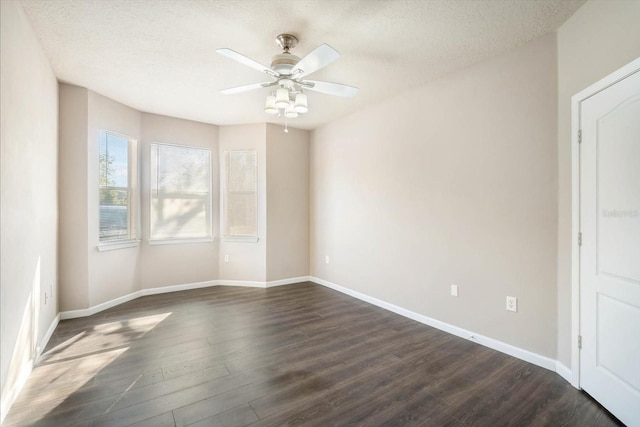 unfurnished room featuring a textured ceiling, ceiling fan, dark wood-type flooring, and baseboards