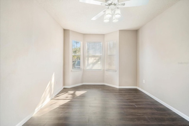 unfurnished room featuring dark wood-style floors, baseboards, and a ceiling fan