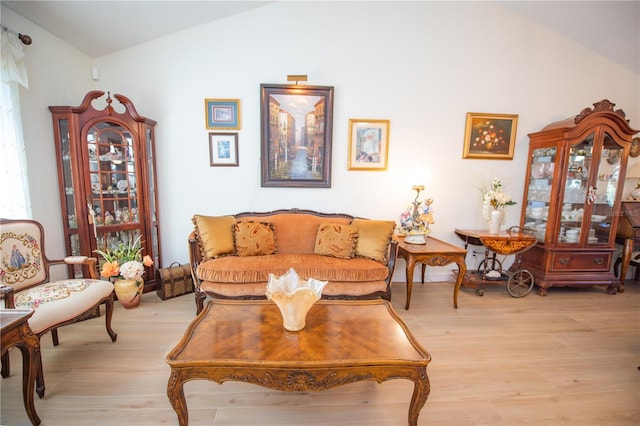 living room with vaulted ceiling and light wood-type flooring