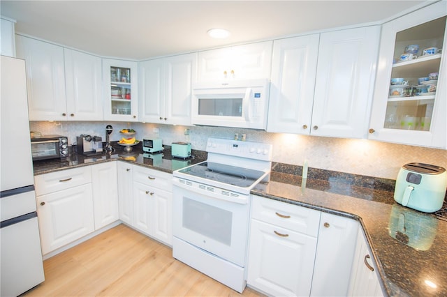 kitchen with white appliances, decorative backsplash, white cabinets, and light wood-style floors