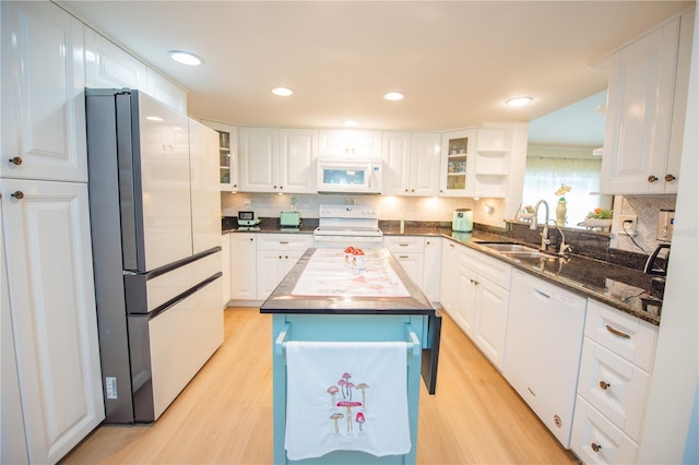 kitchen featuring white appliances, a sink, light wood-style flooring, and white cabinets