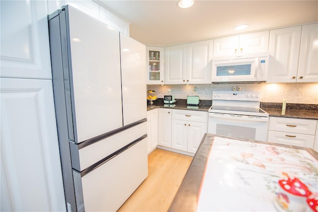 kitchen featuring white appliances, light wood-type flooring, backsplash, and white cabinets