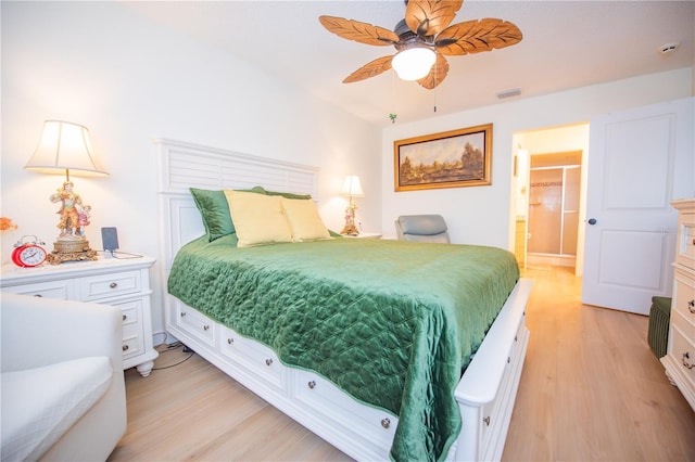 bedroom with light wood-type flooring, a ceiling fan, visible vents, and connected bathroom