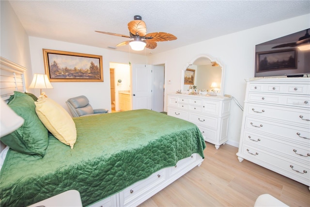 bedroom featuring a ceiling fan, a textured ceiling, light wood finished floors, and ensuite bathroom