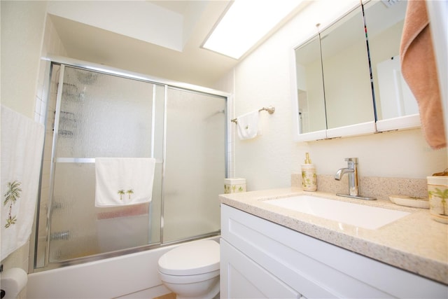 full bathroom featuring shower / bath combination with glass door, vanity, and toilet