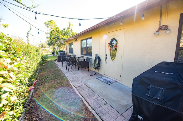 entrance to property featuring stucco siding and a patio