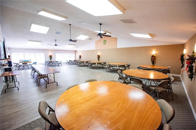 game room featuring lofted ceiling, a textured ceiling, visible vents, and wood finished floors